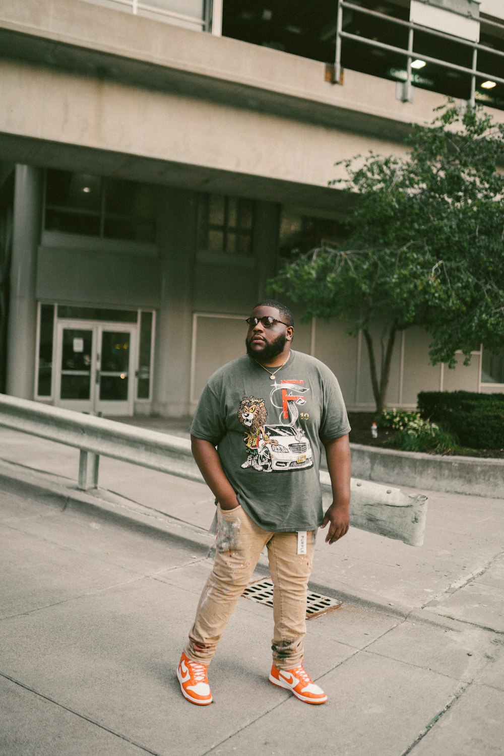 a man standing on a sidewalk in front of a building