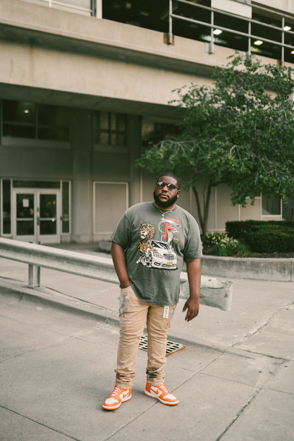 a man standing on a sidewalk in front of a building