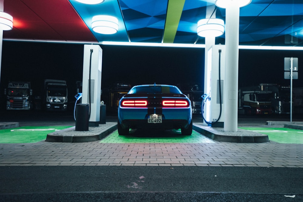 a blue car is parked in a gas station