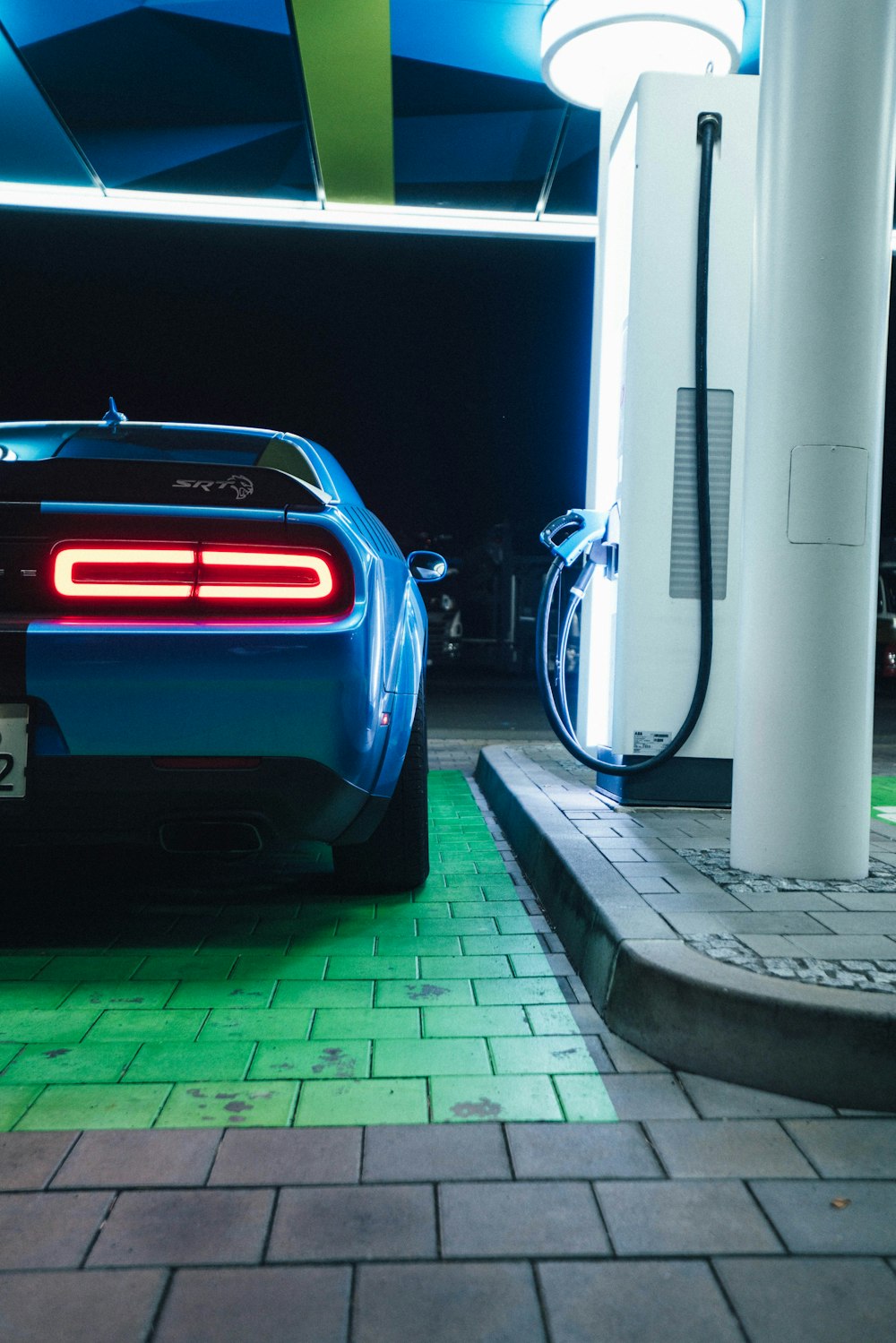 a blue sports car is parked at a gas station