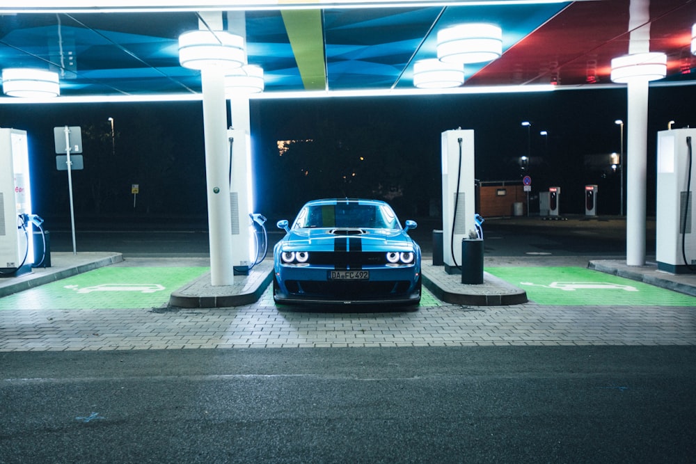 a blue car is parked at a gas station