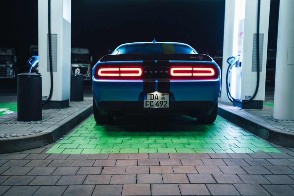 a blue sports car parked at a gas station