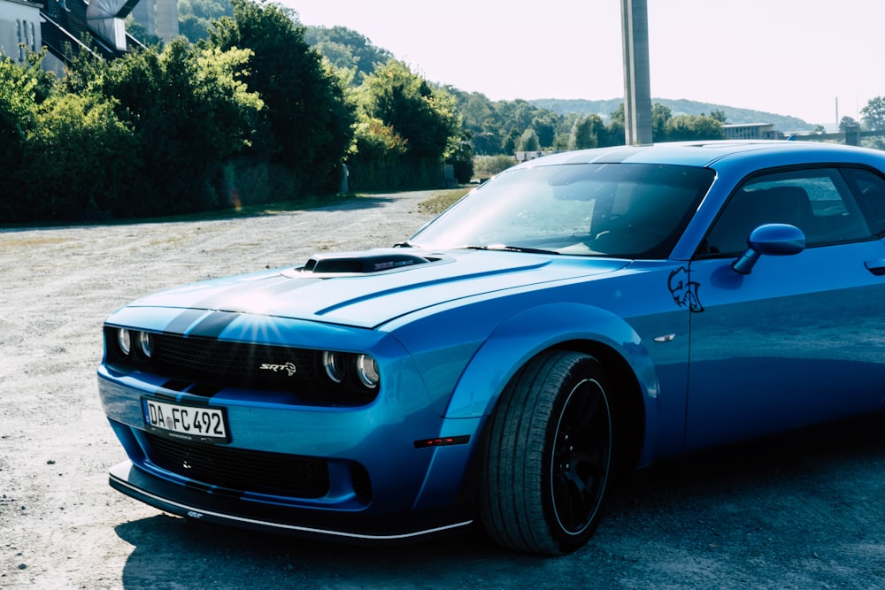 a blue sports car parked on the side of a road