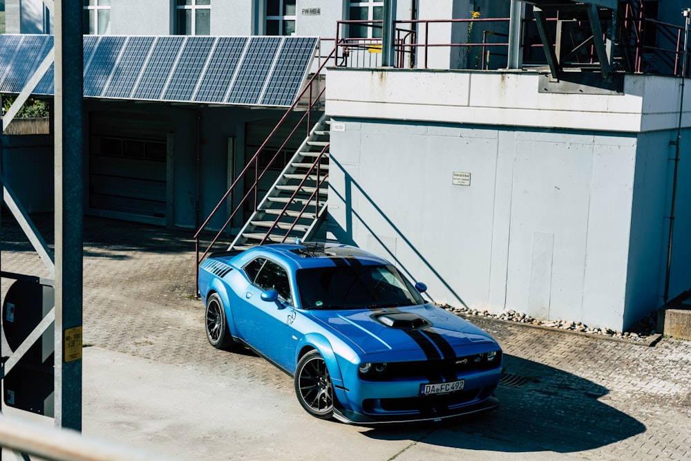 a blue sports car parked in front of a building