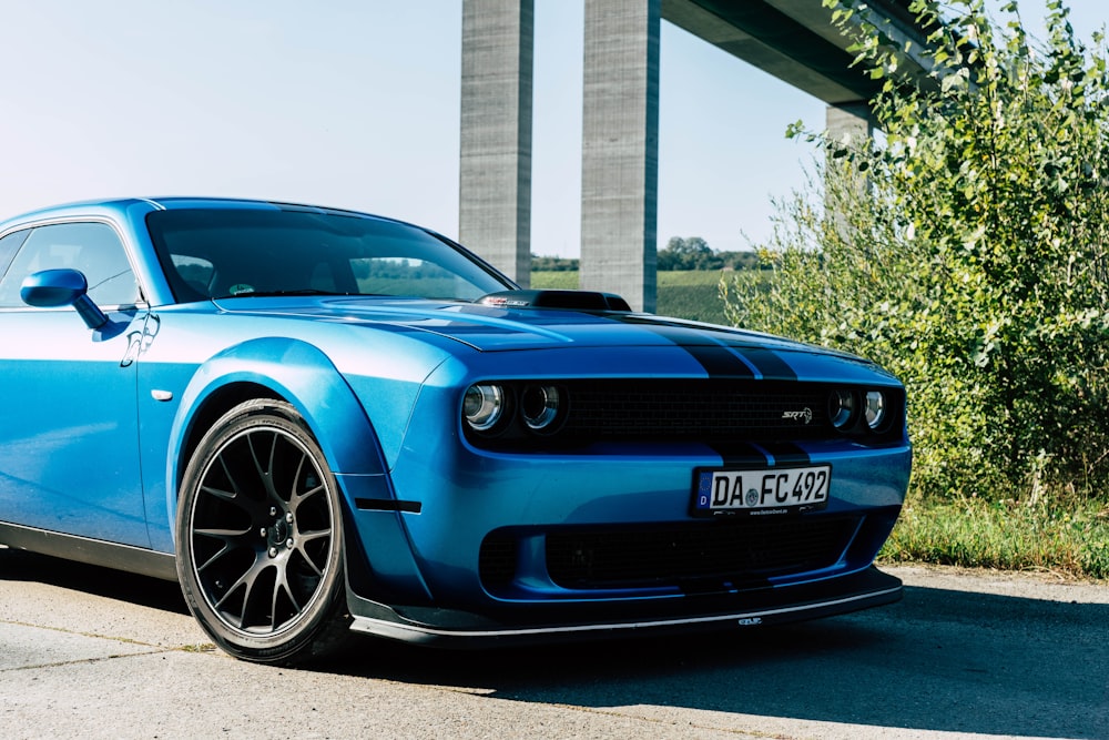 a blue sports car parked on the side of the road