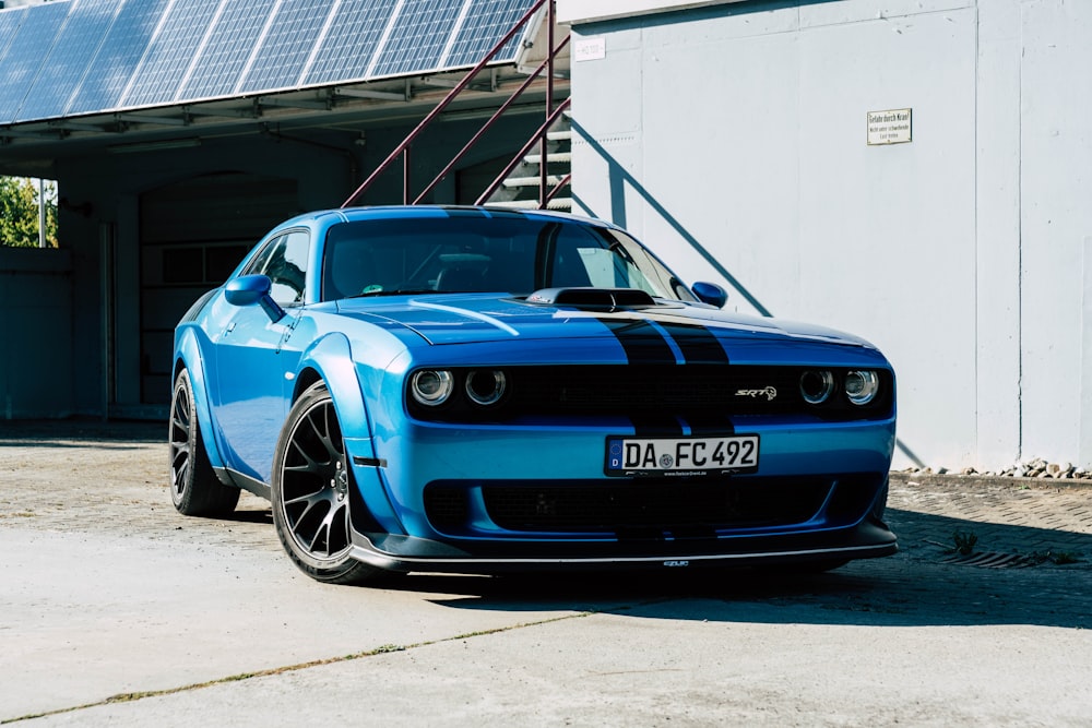 a blue sports car parked in front of a building