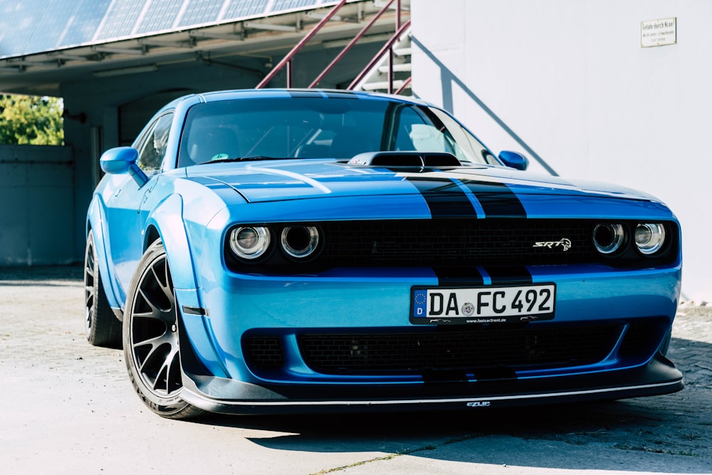 a blue sports car parked in front of a building