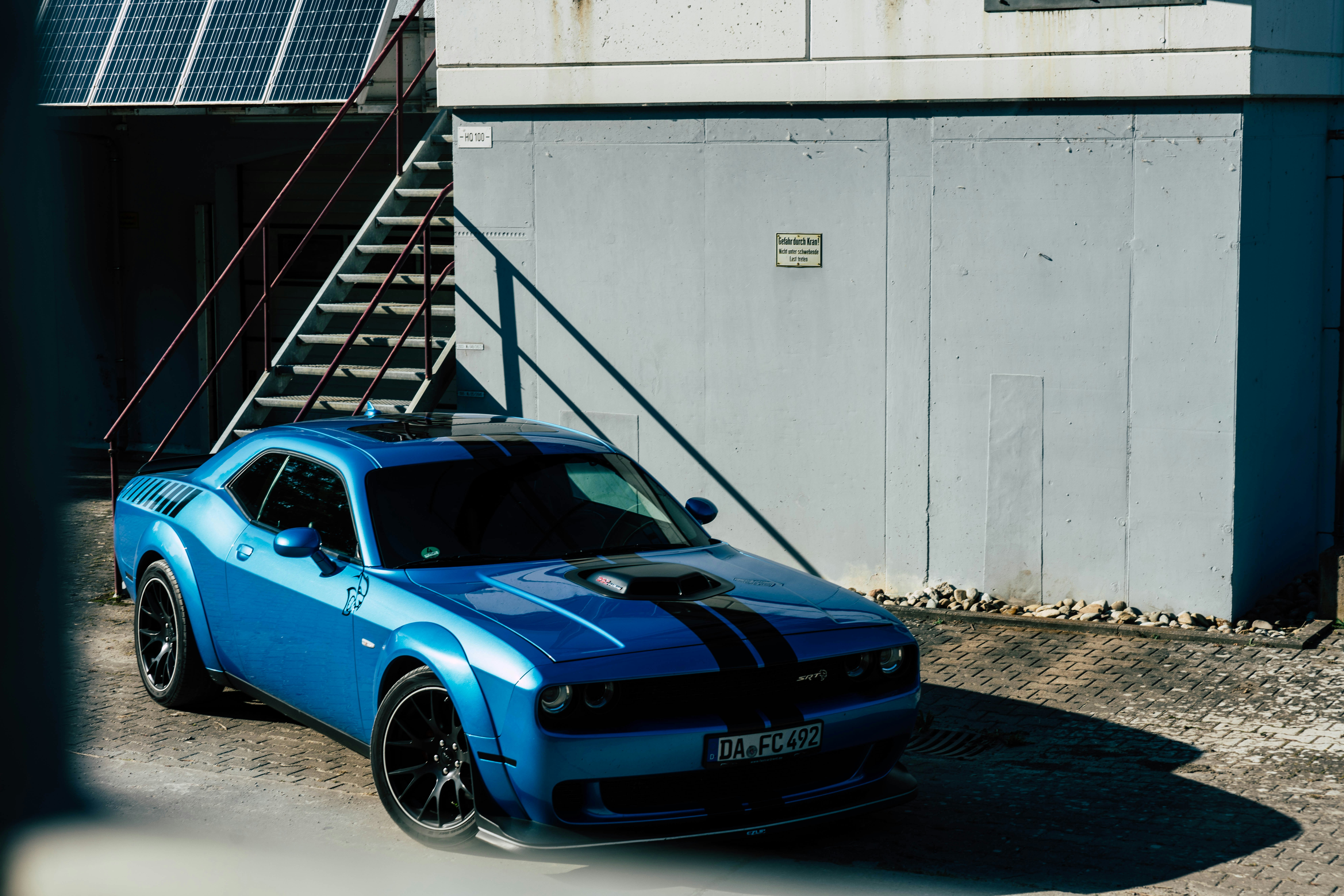 Ein blauer Sportwagen parkt vor einem Gebäude