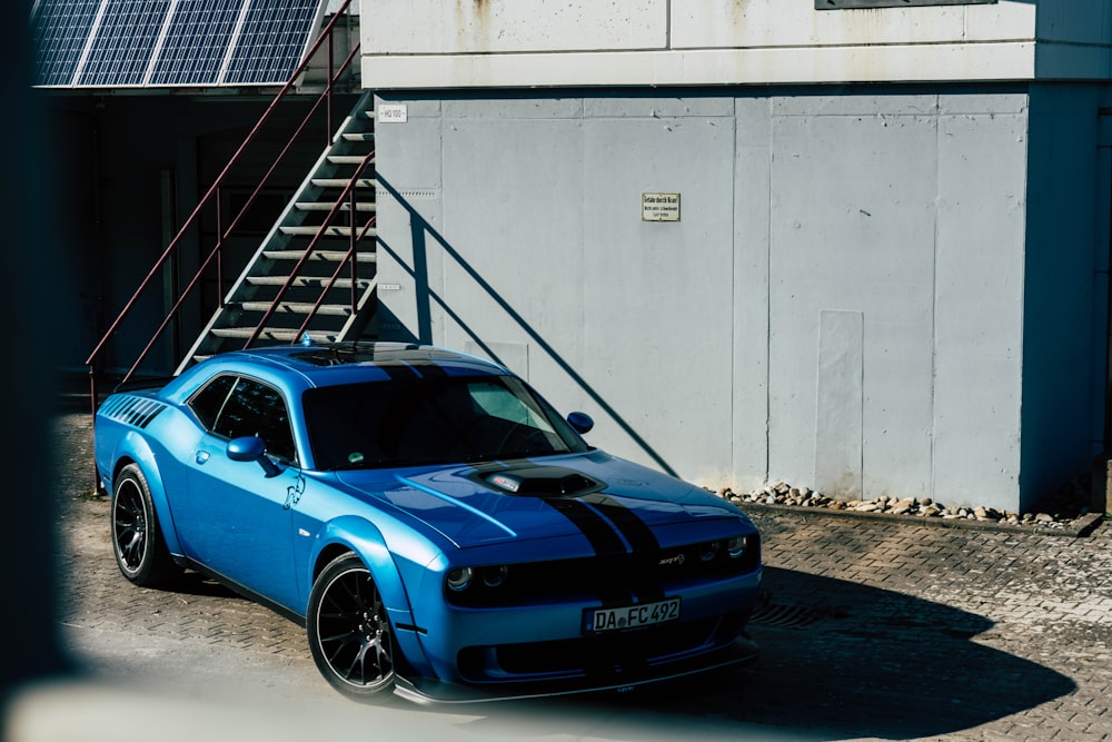 a blue sports car parked in front of a building