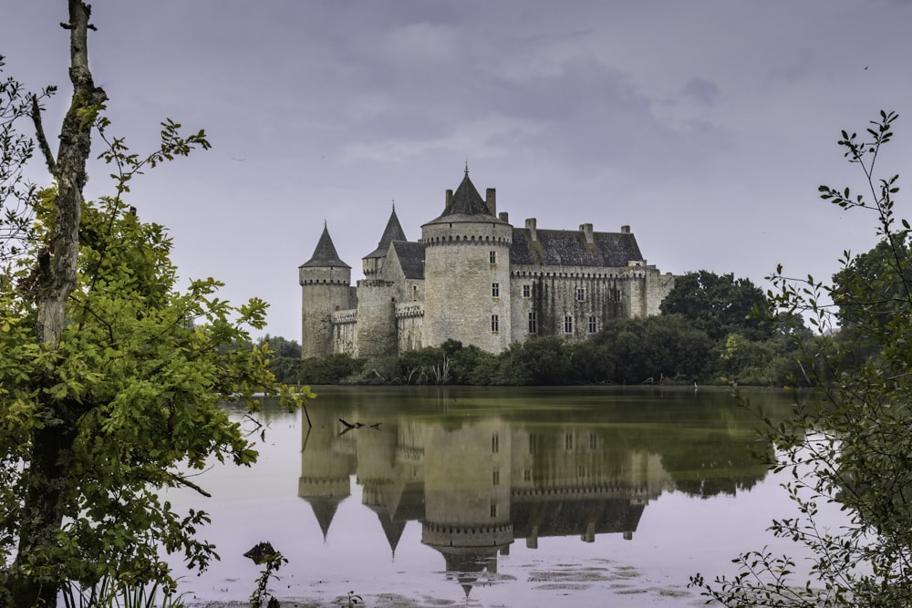 un château avec un lac devant lui