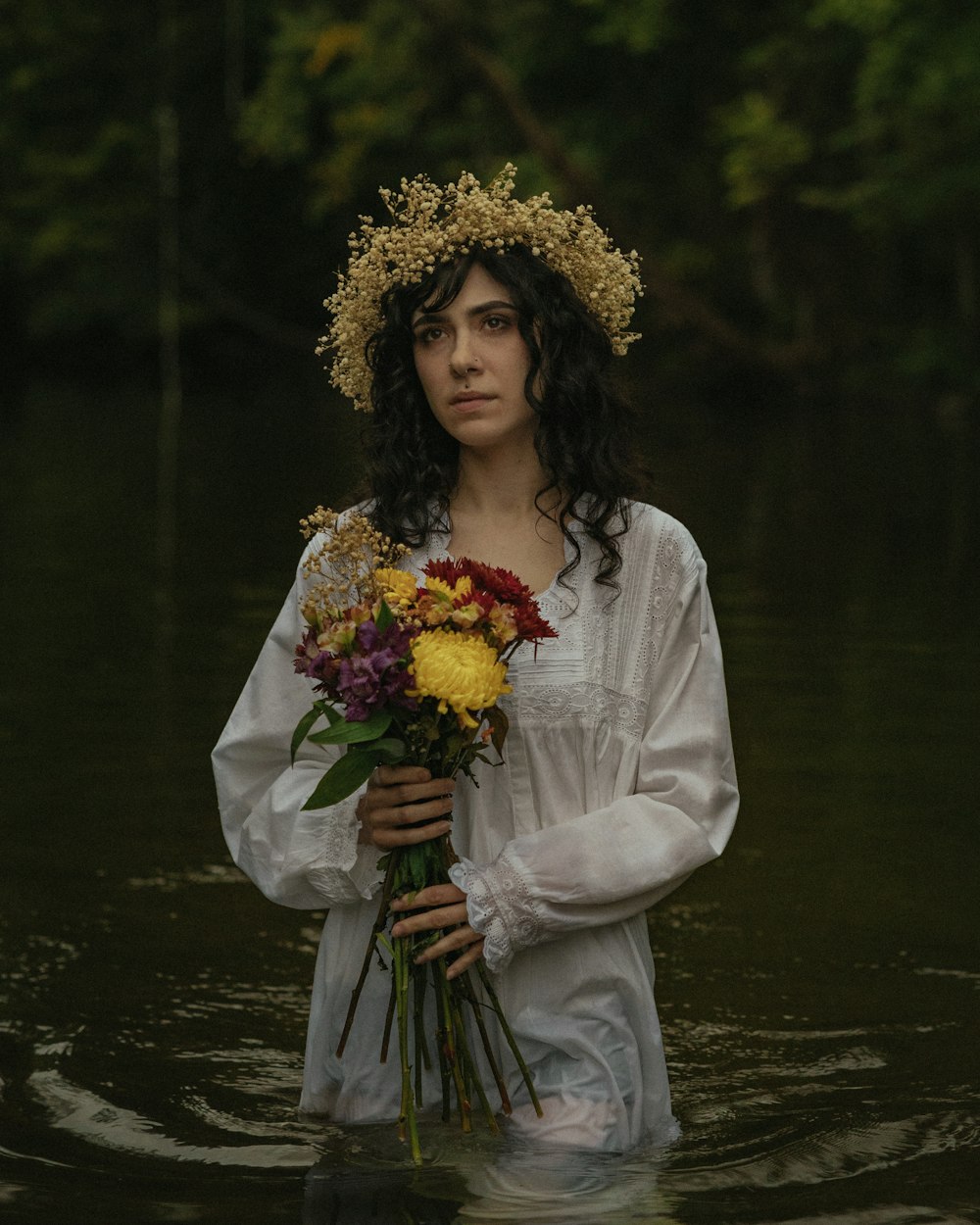 Una mujer con un vestido blanco sosteniendo un ramo de flores