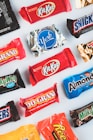 a variety of candy bars lined up on a white surface