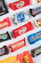 a variety of candy bars lined up on a white surface