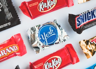 a variety of candy bars lined up on a white surface