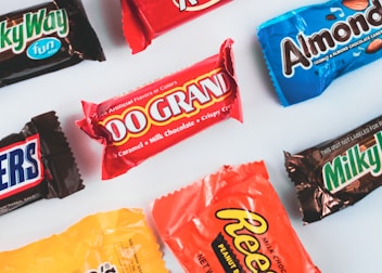 a variety of candy bars lined up on a white surface