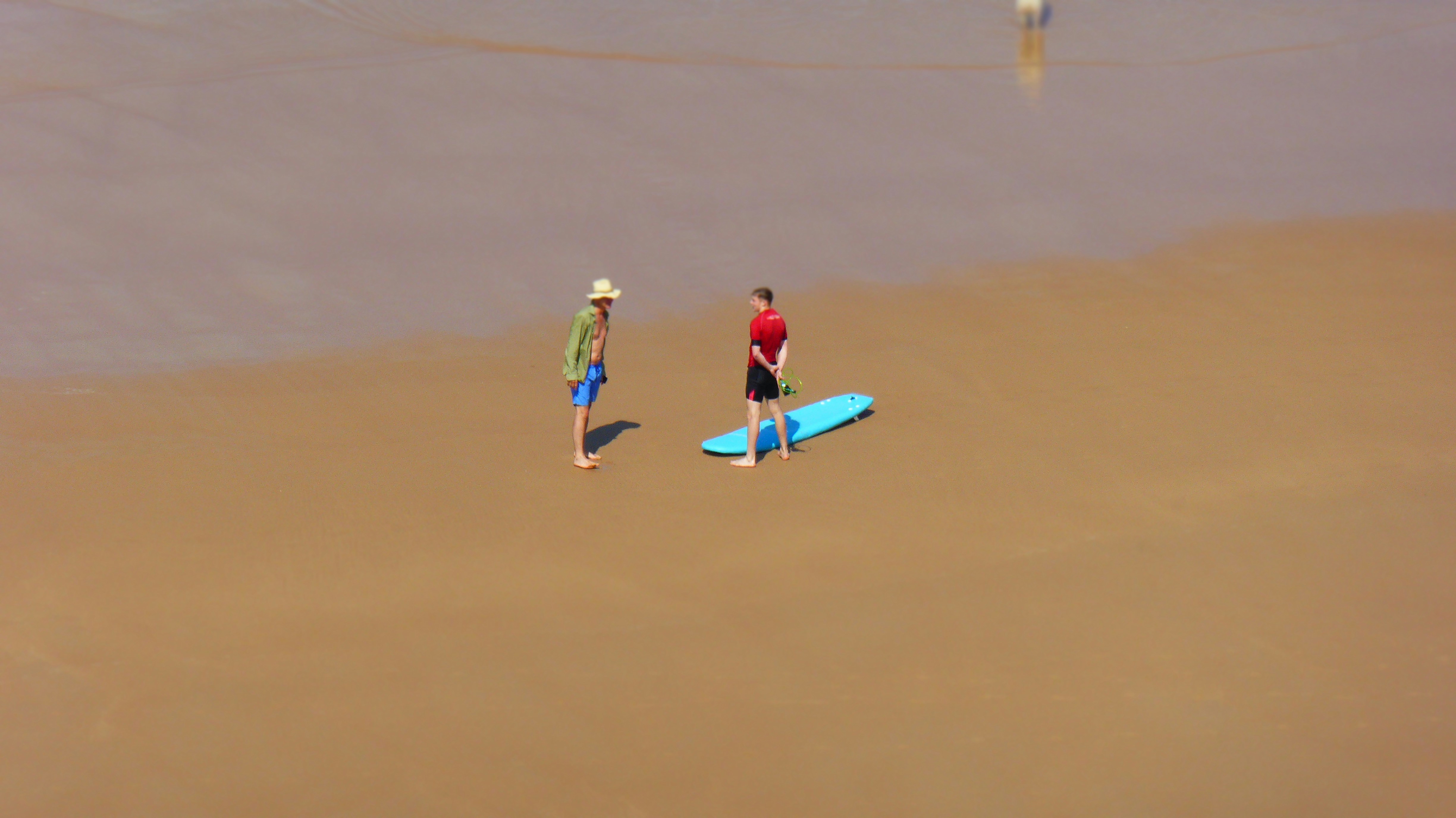a couple of people standing on top of a beach