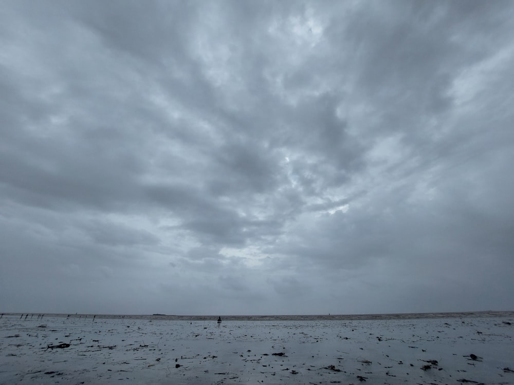 a cloudy sky is seen over a barren field