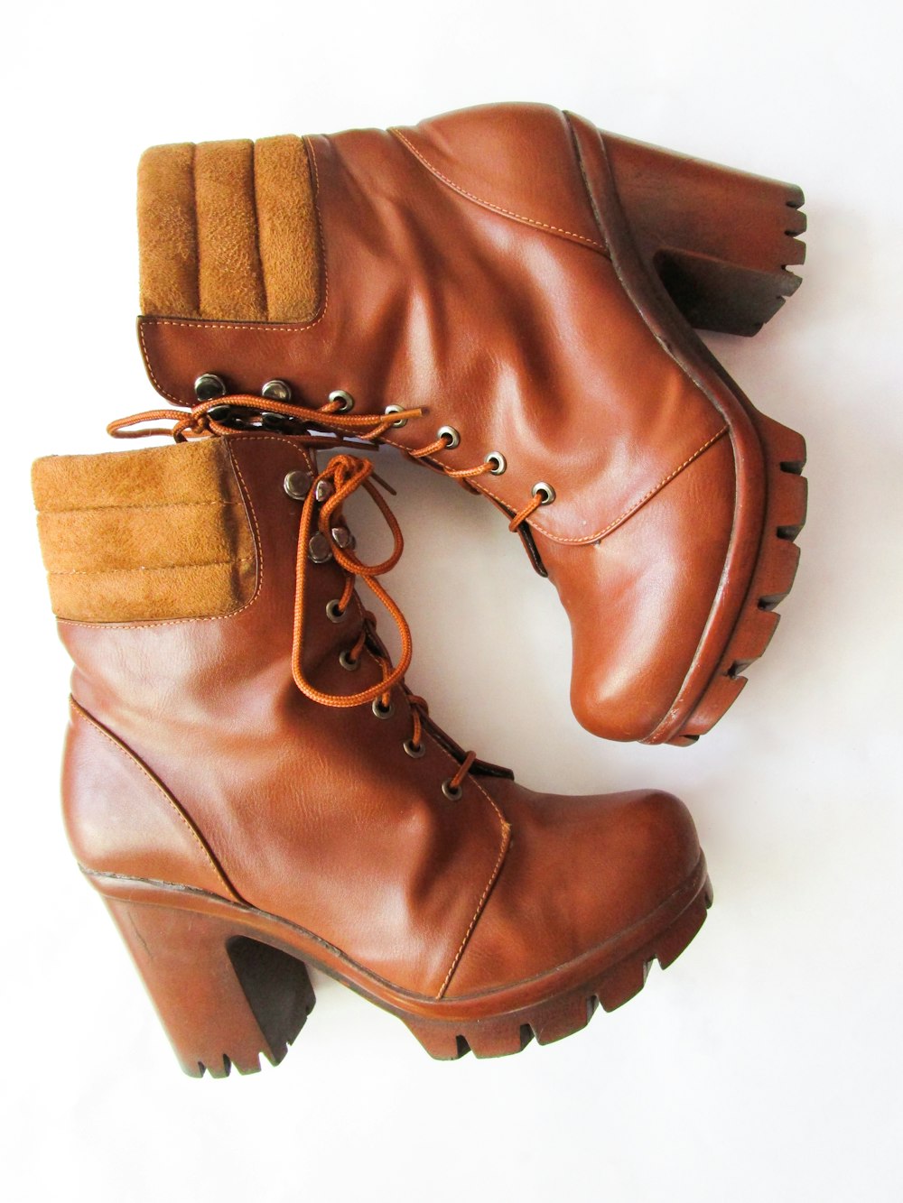 a pair of brown boots sitting on top of a white floor