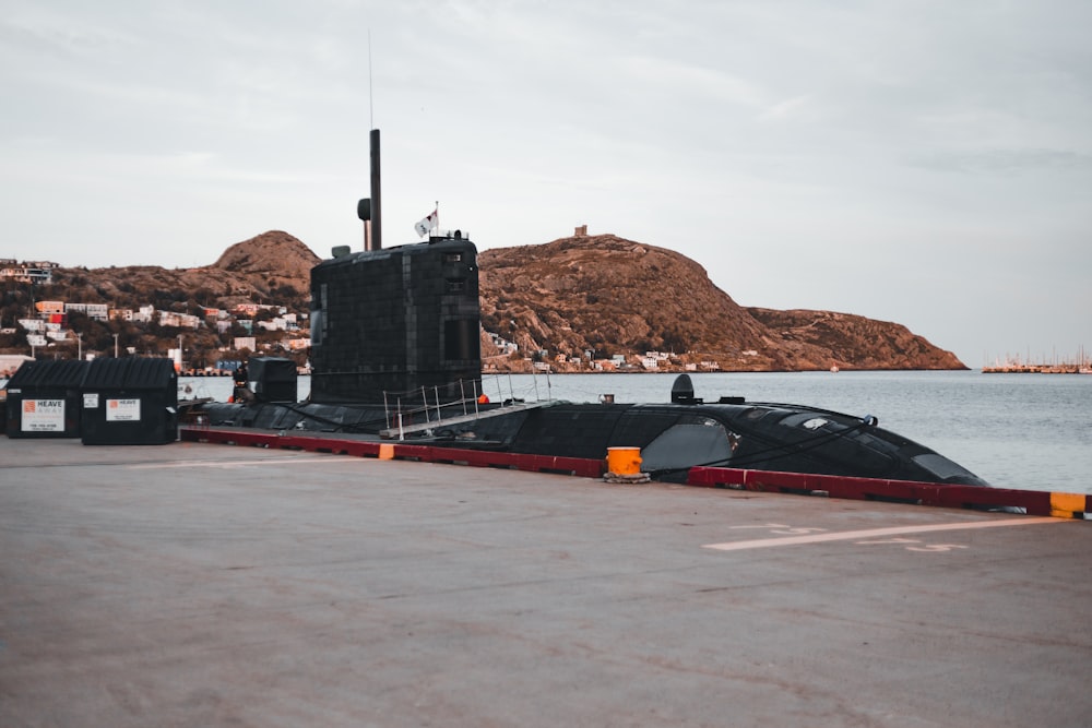 a large black submarine sitting on top of a body of water