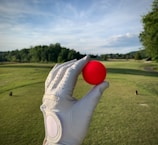 a person holding a red ball in their left hand