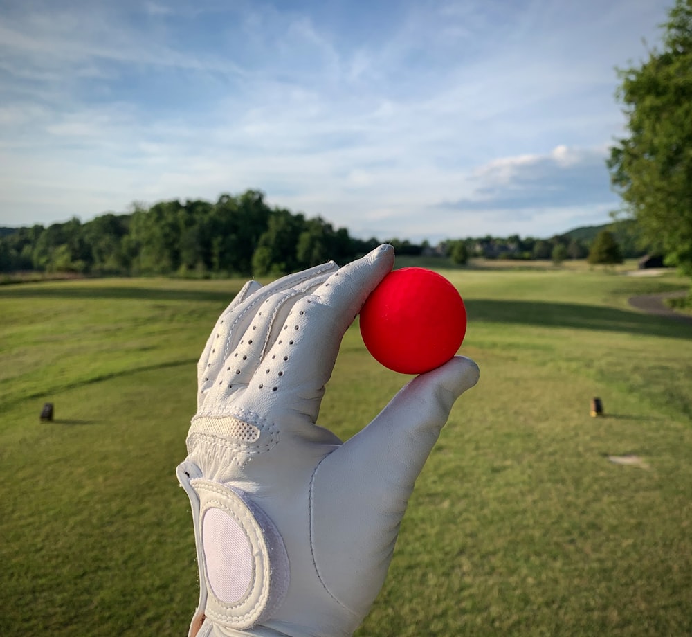 a person holding a red ball in their left hand