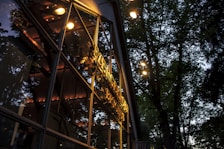Hotel exterior at dusk with glowing windows and surrounding greenery.