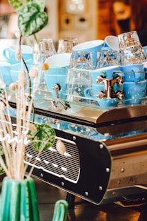 Stacked ceramic cups showcasing a range of blue and green glazes catching soft light.
