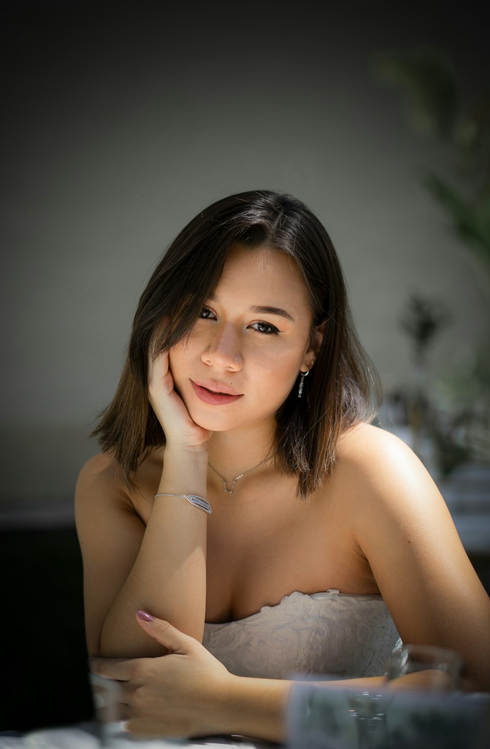 a woman sitting at a table with her hand on her chin