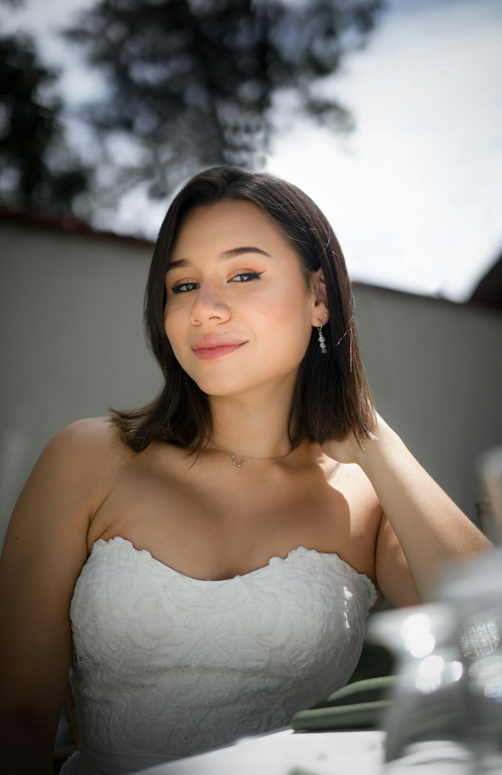 a woman in a white dress sitting at a table