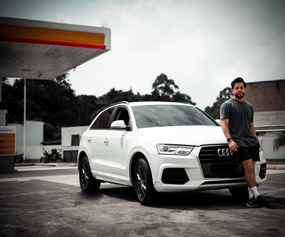 a man standing next to a white car