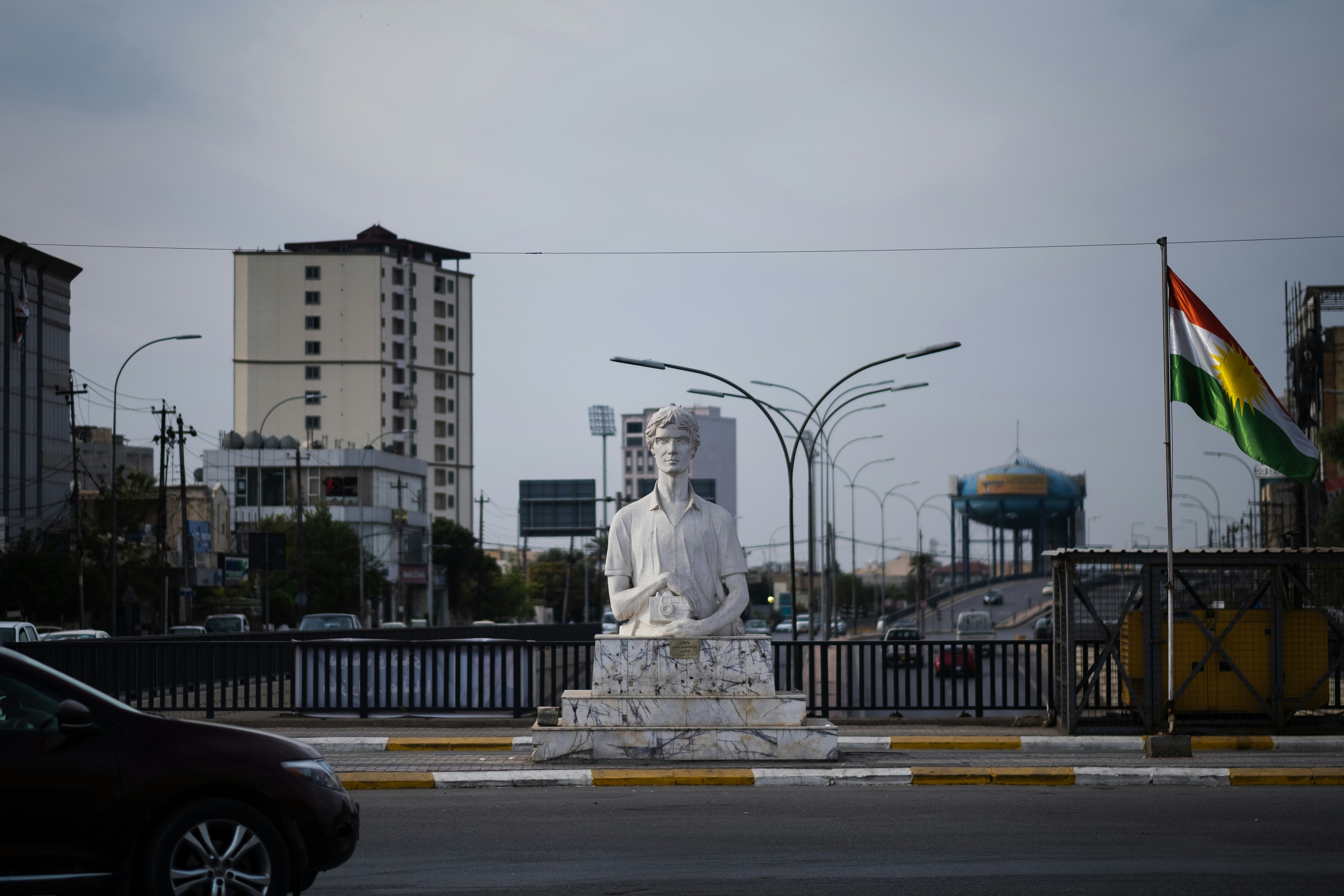 a statue of a man sitting on top of a white statue