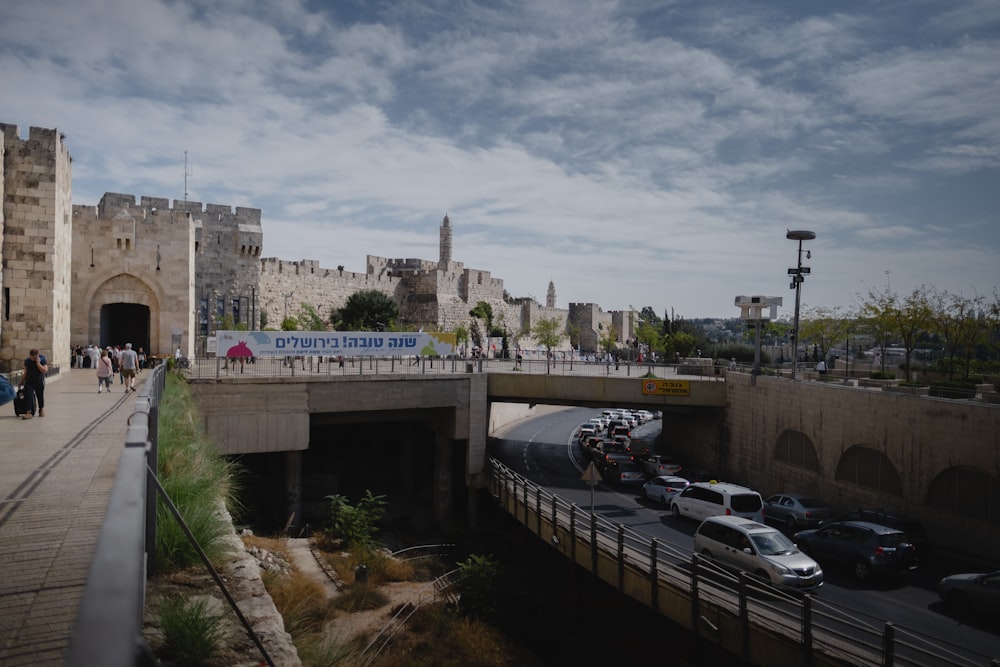 a group of people walking across a bridge over a river