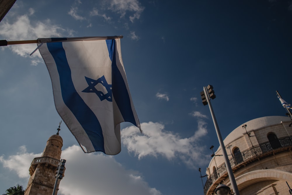 a flag flying in the wind in front of a building