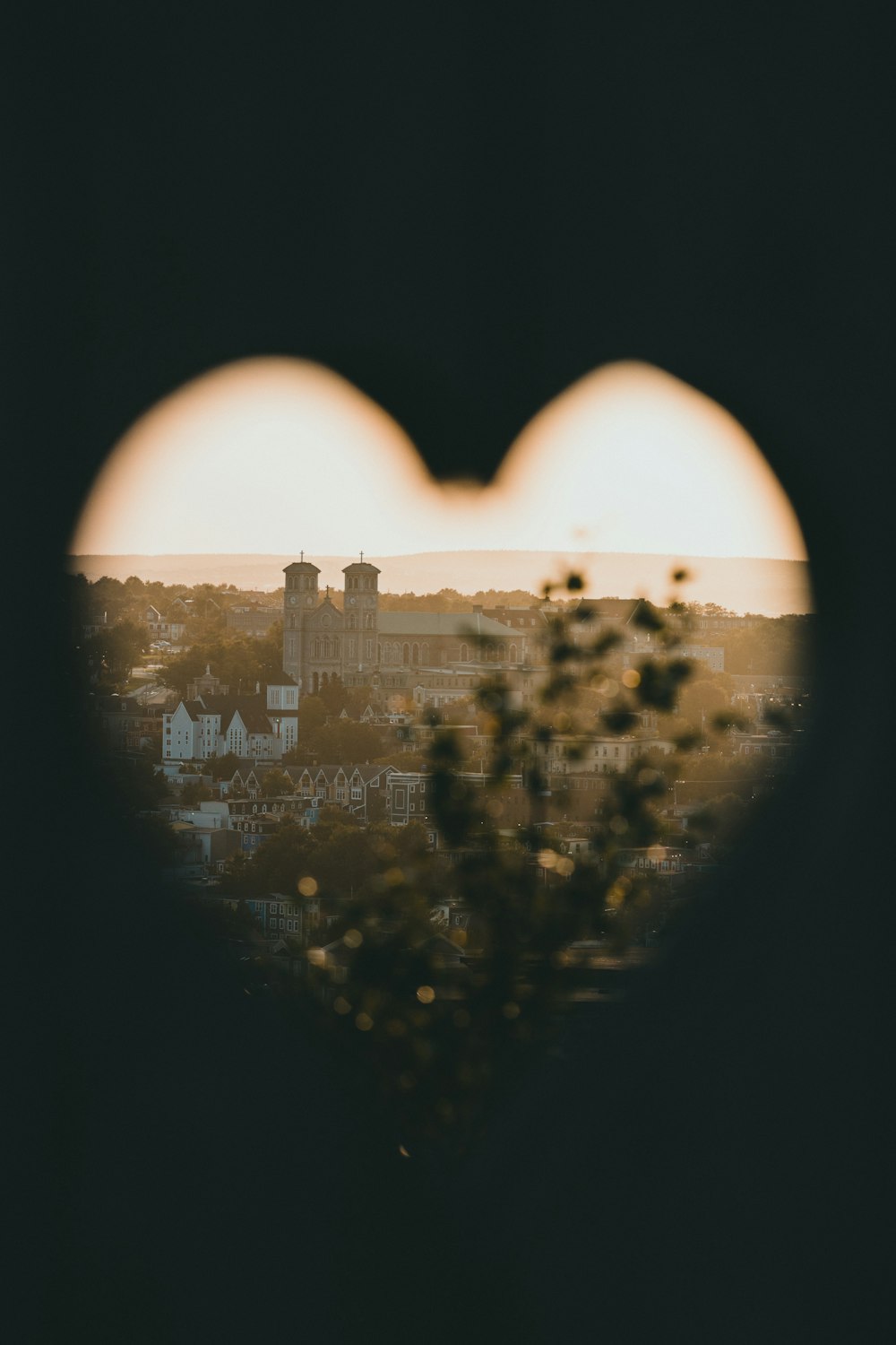 a view of a city through a heart shaped window