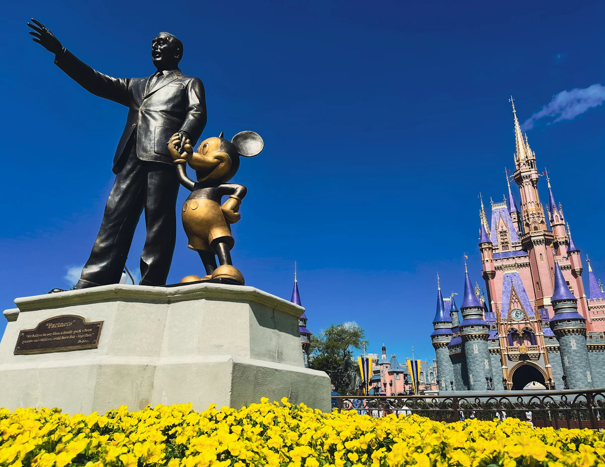A statue of Walt Disney and Mickey Mouse in front of Cinderella Castle at Walt Disney World