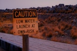 a yellow caution sign sitting on top of a wooden bridge