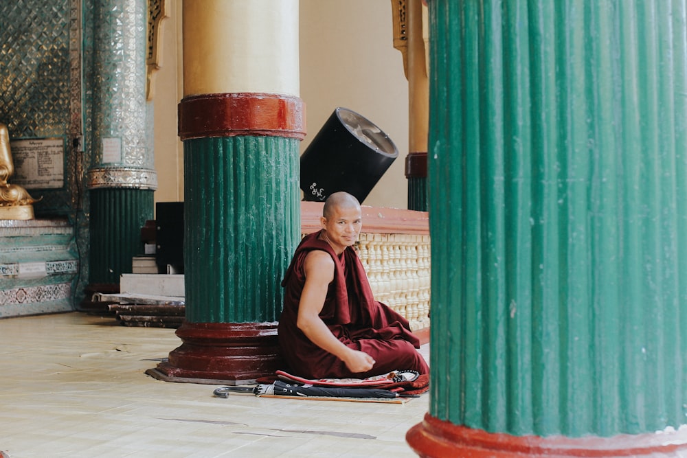 a monk sitting on the floor in a temple