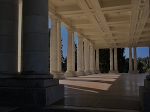 a row of columns in a building with a blue sky in the background