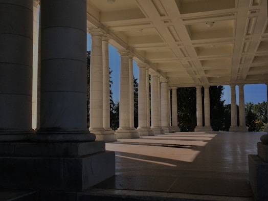 a row of columns in a building with a blue sky in the background