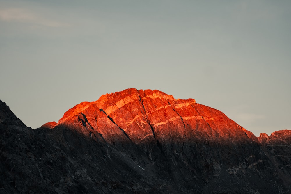 a large mountain with a bright orange light on top of it