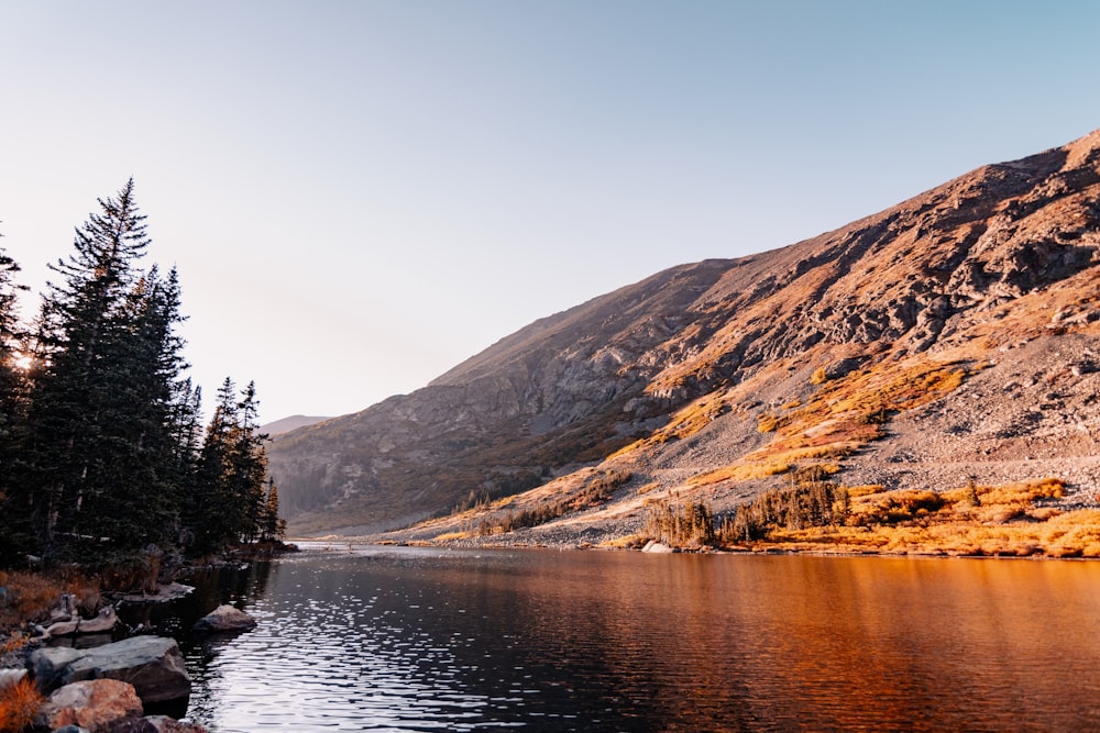 un plan d’eau entouré de montagnes et d’arbres