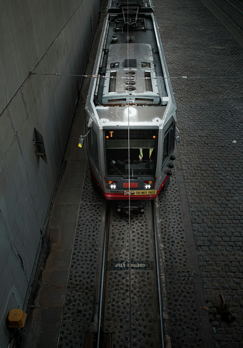 a train traveling down train tracks next to a wall