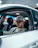 a man sitting in a car wearing a hat