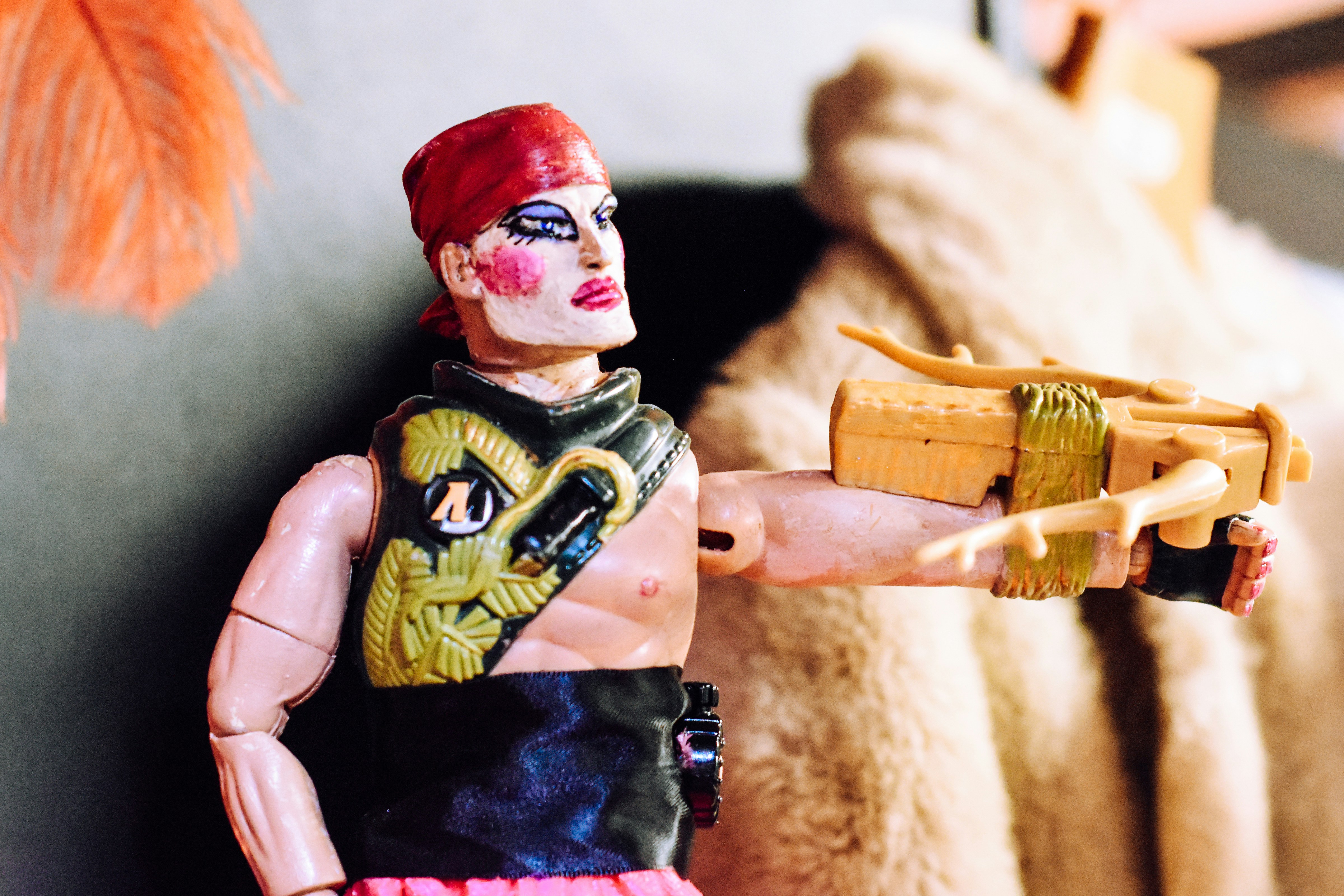 um close up de uma figura de ação segurando uma arma de brinquedo