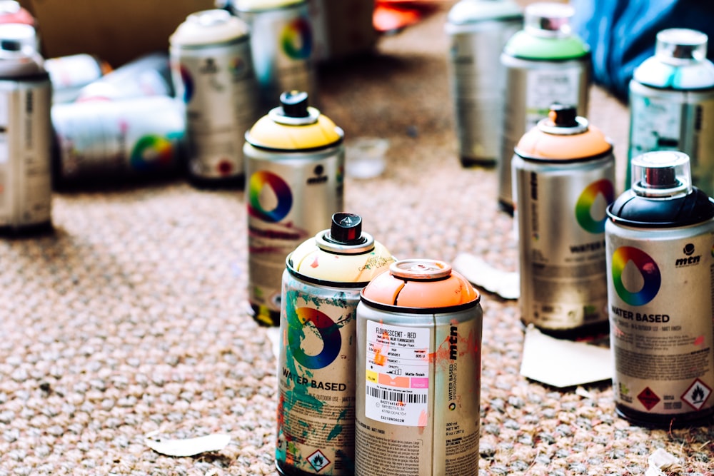a group of cans of paint sitting on the ground