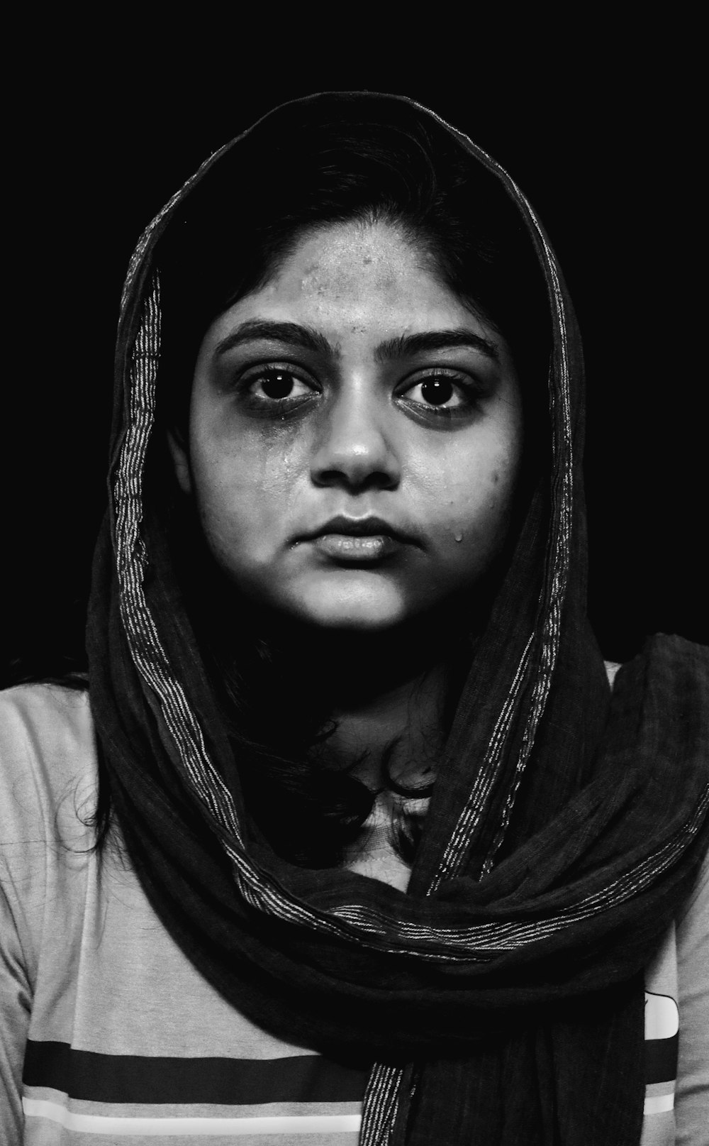 a black and white photo of a woman wearing a scarf