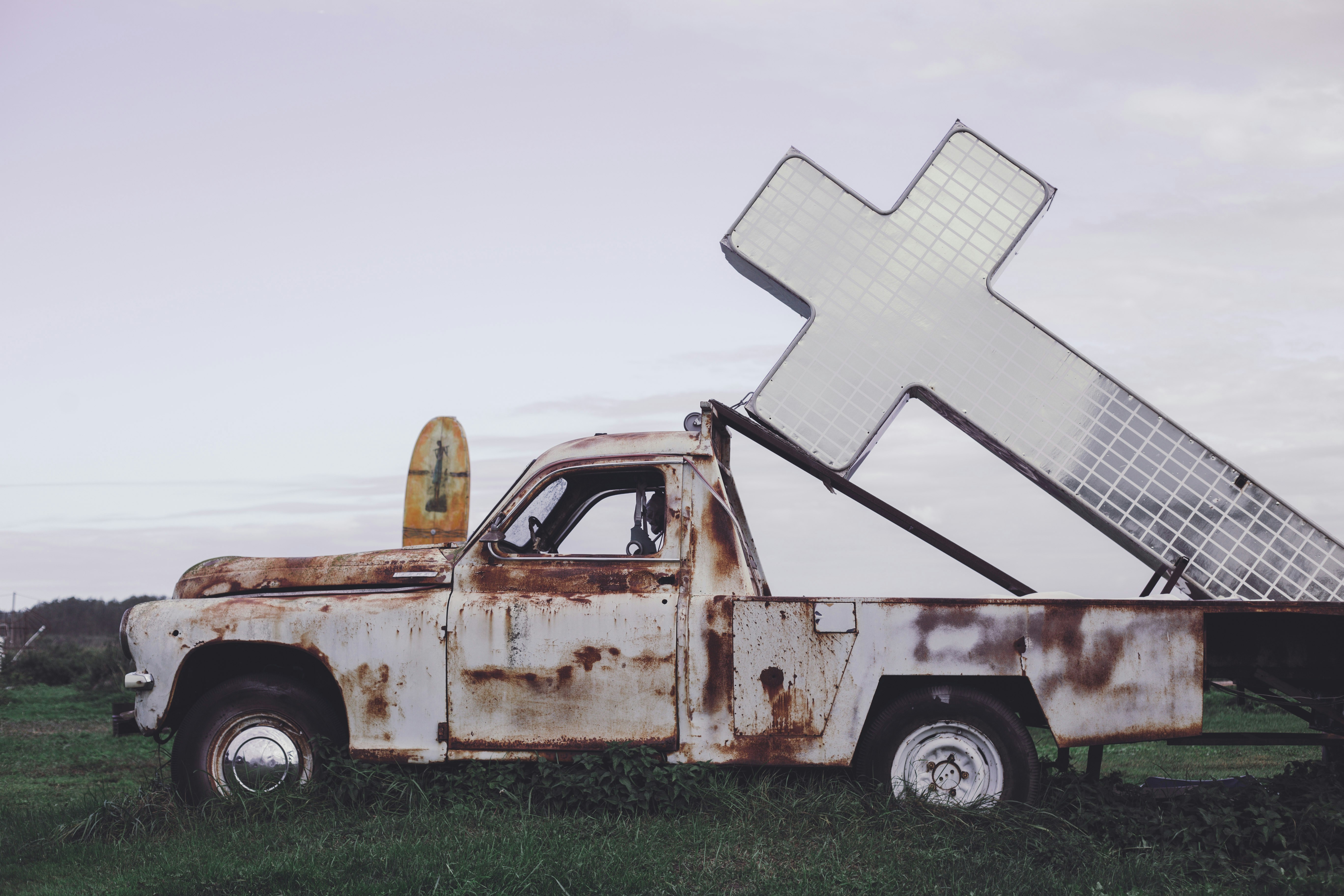 an old truck with a cross on the back of it