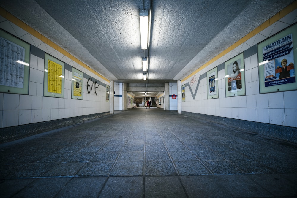 an empty hallway with posters on the wall