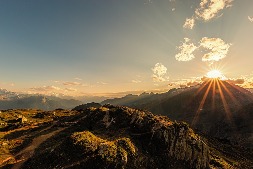 the sun is setting over a mountain range