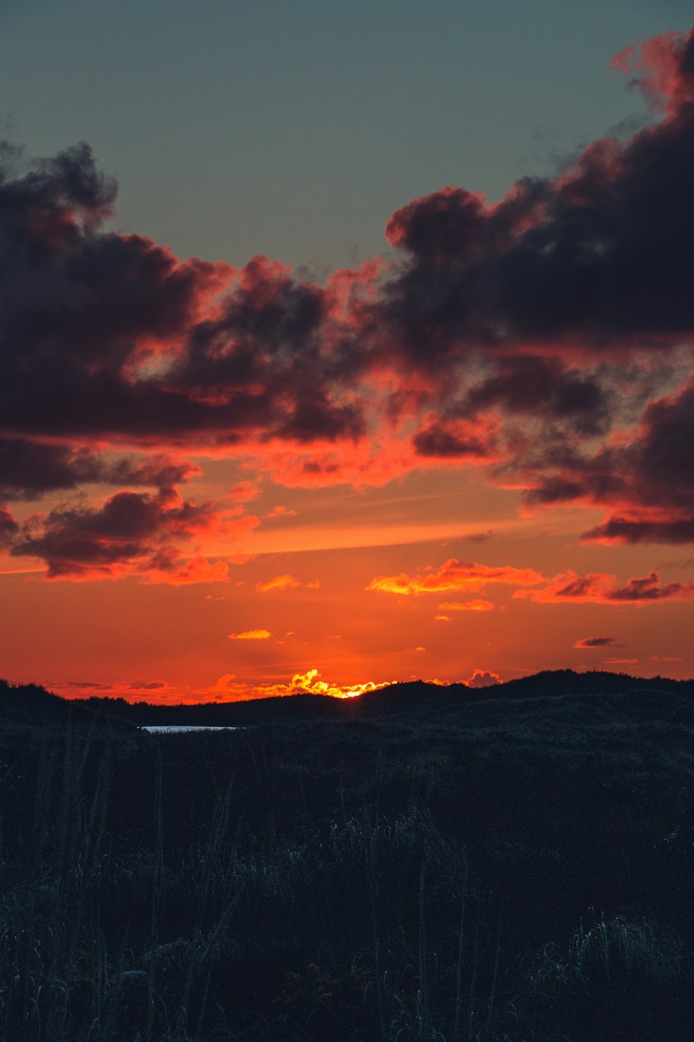 the sun is setting over a mountain range